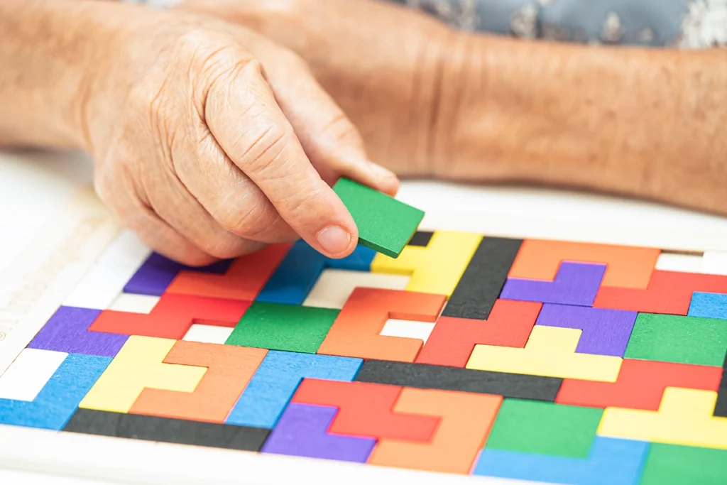 Tetris-Puzzle aus bunten Formen wird gelöst bei der Ergotherapie zur Behandlung sensomotorisch perzeptiver Störungen.