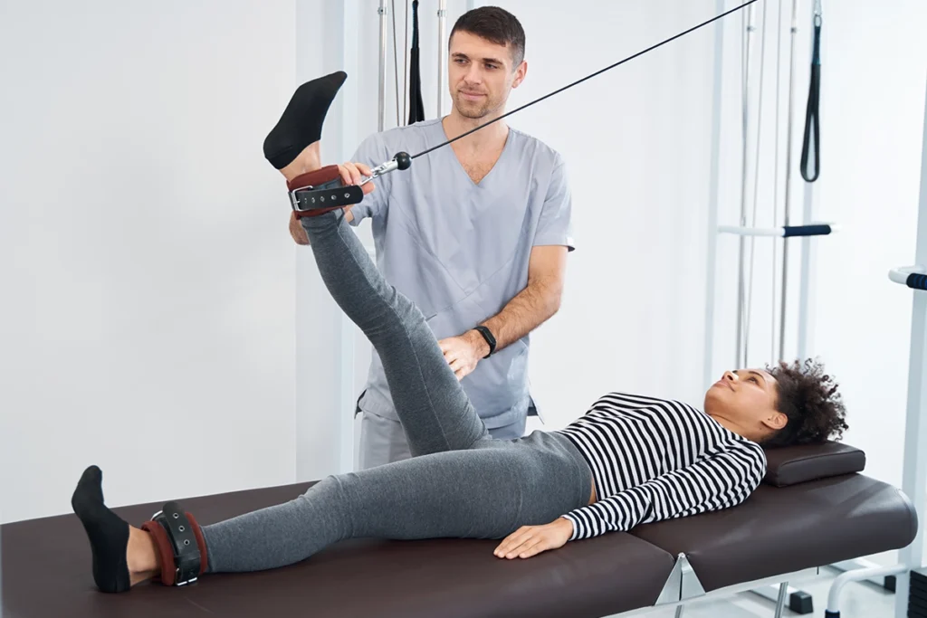 Physiotherapeut begleitet eine Patientin bei der medizinischen Trainingstherapie (MTT). Speziell abgestimmte Übungen fördern Kraft, Stabilität und Beweglichkeit zur langfristigen Rehabilitation.