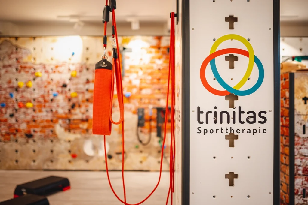 Ein Seilzug für Übungen befestigt an einem Pfeiler mit dem Trinitas Logo