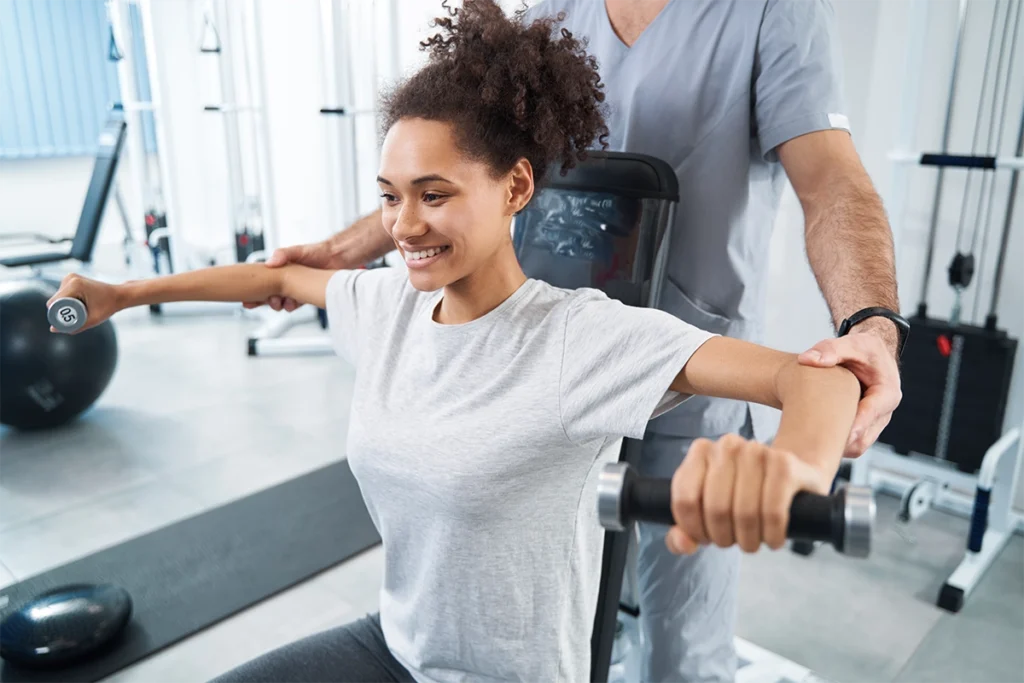 Armtraining eines Physiotherapeuten mit Patienten